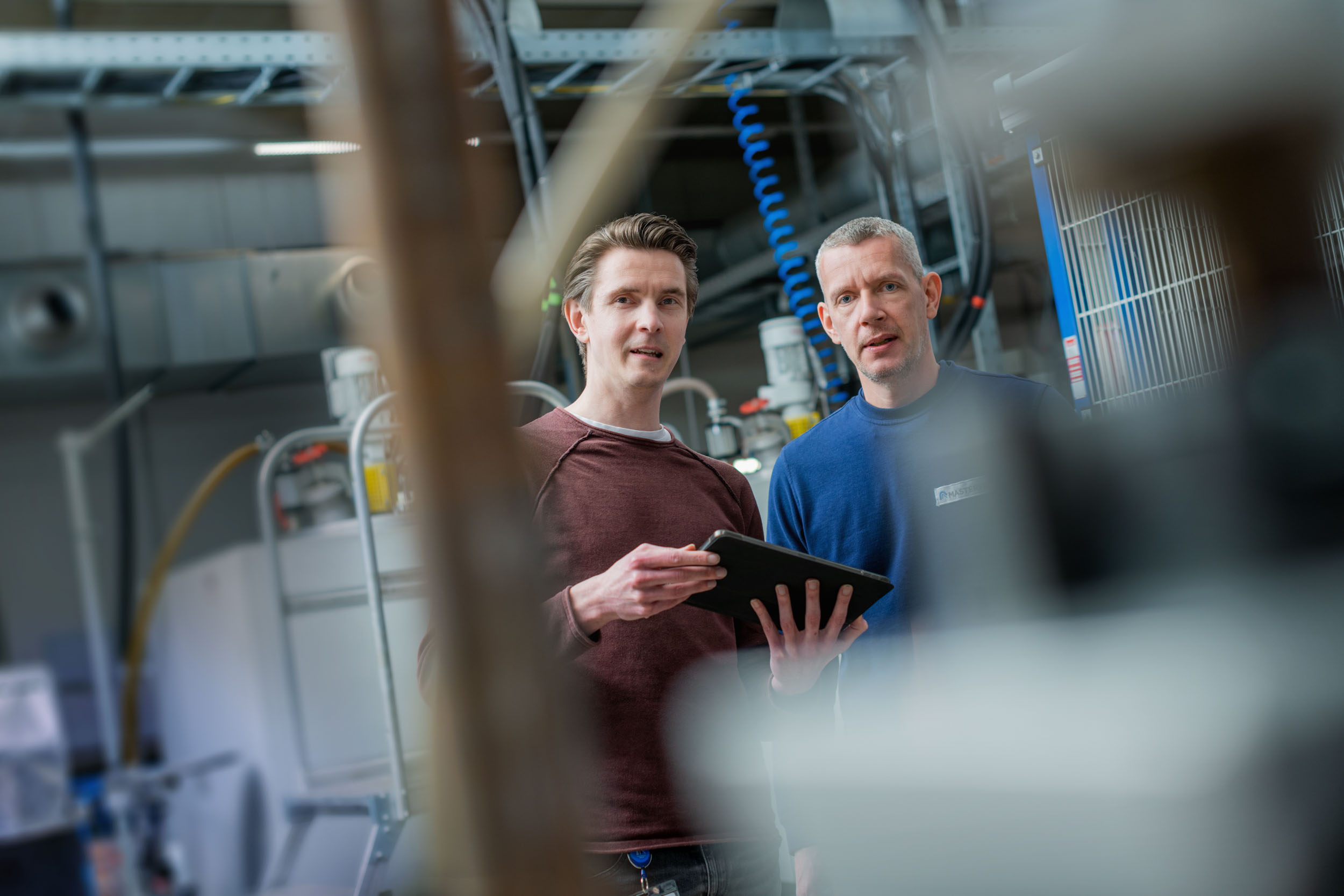 Imagem de exemplo: Funcionários em pé com um ipad na unidade de produção de Gelsenkirchen